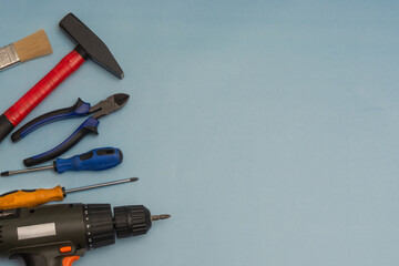 Set of tools for a builder or electrician on a blue background. Flat layout. There is space for text