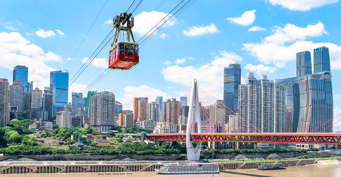 A Chongqing cable car crosses the Yangtze River from Yuzhong District, passing the Dongshuimen bridge - words on cable car translates as 'Chongqing: a tour in Chongqing, a gain in vision'