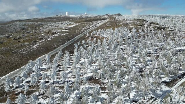 Vista a&eacute;rea de monta&ntilde;as nevadas y c&uacute;pulas de observatorio del calar alto.