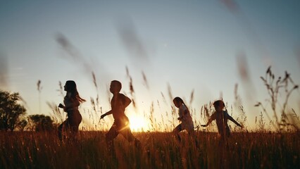 Children running in park at sunset. happy family kindergarten kids dream concept. Kids running in...