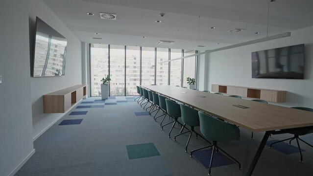 Modern Meeting Room with Chairs, Conference Table and Two TV's. Corporate boardroom interior with minimalist design. Comfortable seating in a contemporary workspace