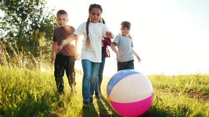 family of children play with a ball in the park. children dream: play soccer in park, running fast...