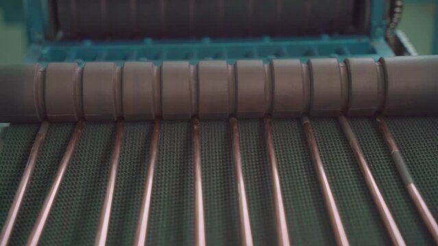 Factory production of heat exchanger. Copper and steel pipes coming out on line from Heavy pipe reducer machinery in workshop. Lots of pipes to produce. Heating element. Close up.