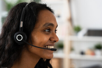 Side view of smiling call center worker. Telephone assistance service concept.
