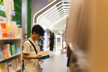 Young boy reading book in a book store.