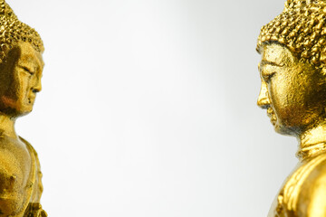 A golden statue of a Buddhist figure meditating facing the side isolated on white background....