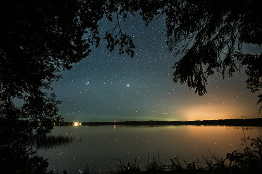 Valdai Lake against the background of the starry sky and the forest