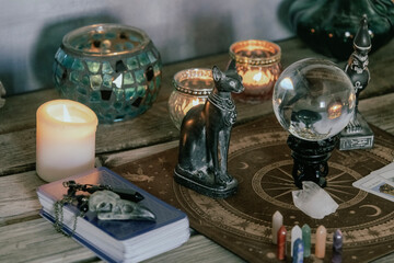 An atmospheric setting featuring a crystal ball, Egyptian cat statues, candles, and crystals, creating a mystical ambiance.
