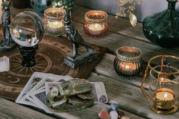 An atmospheric setting featuring a crystal ball, Egyptian cat statues, candles, and crystals,...