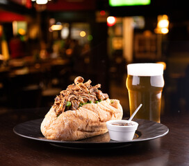 beef stew sandwich with crispy onions and vegetables and barbecue sauce with half pint of beer and...