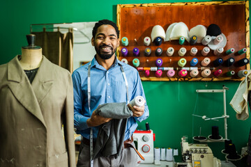 African American man fashion designer choosing thread.