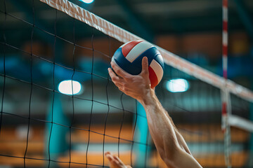 Close-up of a volleyball player's hands hitting the ball for a powerful serve, with the net and...