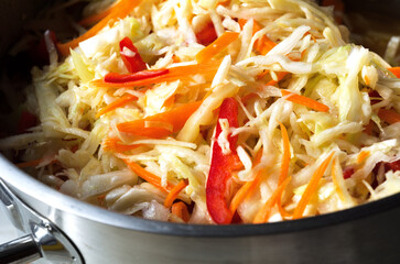 Sauerkraut with carrots and peppers in a saucepan. Autumn harvest.