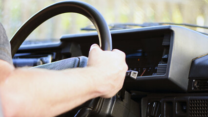hand on the steering wheel of a car. Close-up Of A Man Hands Holding Steering Wheel While Driving Car. old retro car. auto theme