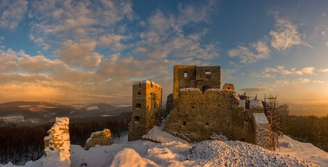 Winter panorama of ruins of carpathian castle Hrusov in Slovakia lit by sun light built on hill...