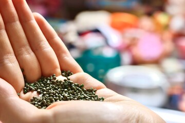 Plastic granules on a hand symbolizing polymer and plastic industry raw material used for production and plastic consumption of modern society
