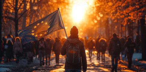 Young man walking on the street with european flag during political demonstrations.