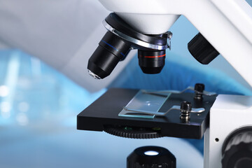 Scientist working with modern microscope indoors, closeup