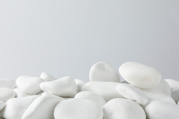 Presentation for product. White pebbles on light background. Space for text