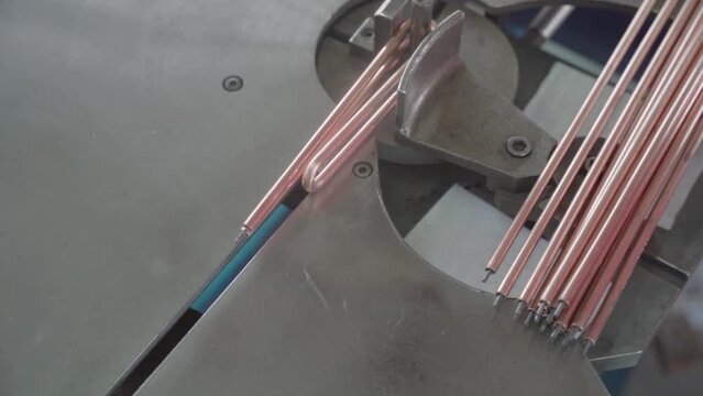 Factory production of heating element. Heating exchanger workshop. Industrial machine bending metal rod. Manufacturing heating element. Mass factory production.
