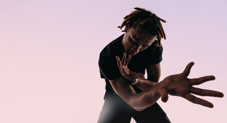 Expressive gen z dancing to music with wireless earbuds in a studio silhouette