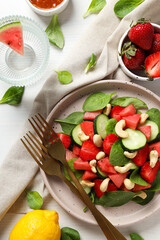 Fresh watermelon salad in a bowl with lemon and strawberries on the table