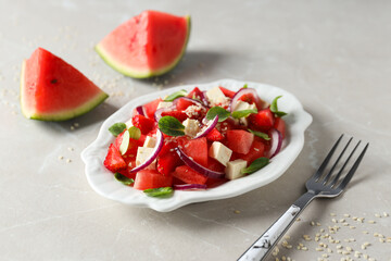 Fresh watermelon salad in a bowl on a light background