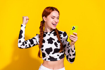 Photo of lucky excited lady dressed cowskin print top winning game modern device isolated yellow...