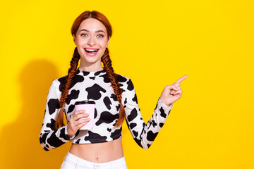 Photo of excited funky woman wear cow skin print top drinking coffee pointing empty space isolated...