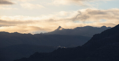 Montanha com nuvens ao p&ocirc;r do sol