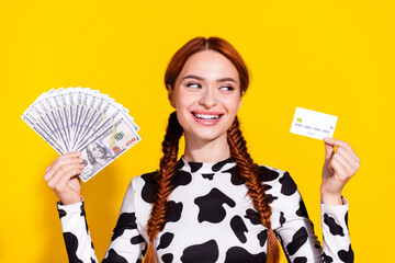 Photo of funny positive lady dressed cowskin print top holding cash fan looking bank card isolated...