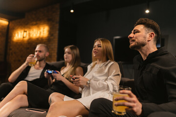 Men observe fierce video game competition among women. Spectators enthusiastically support favorite...