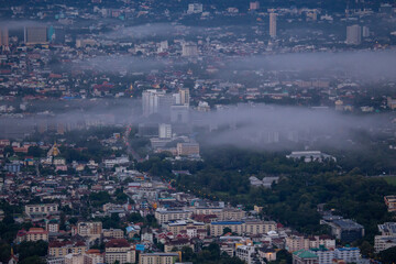 High-angle view of the city with mist passing through. Many buildings in Chiang Mai, Thailand