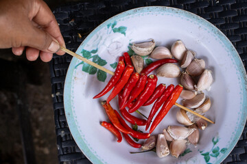 Selective focus red chili on a stick There is white garlic on the plate. I'm about to cook a...