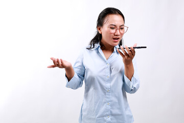 Angry asian business woman asking and shouting at mobile phone, looks outraged, furious while...