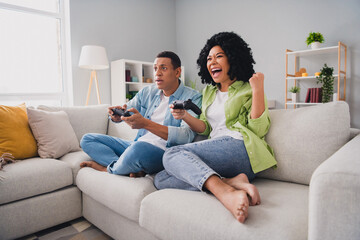 Obraz premium Full size photo of nice young man girl sit sofa play videogame playstation modern interior indoors cozy daylight apartment living room
