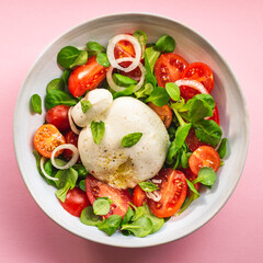 Burrata is a Apulian Italian cheese with a creamy base and a salad of  tomatoes. Summer Italian cuisine, Puglia recipes, summer food. Summer lunch ideas, pink table, square crop