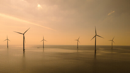 Obraz premium A group of majestic wind turbines stand tall in the ocean off the coast of Flevoland, the Netherlands, harnessing the power of the wind to generate clean energy