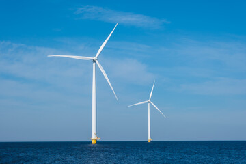 Three colossal wind turbines stand tall and majestic in the vast expanse of the ocean, harnessing the powerful energy of the wind to generate electricity