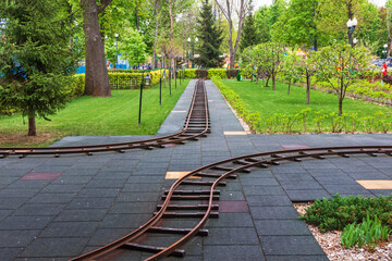 Children's railway in an amusement park. Mini railway attraction rails
