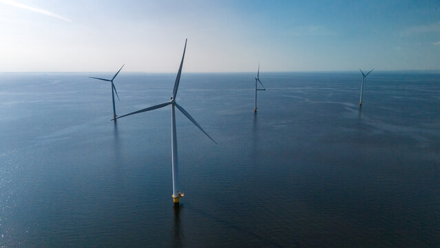 A group of wind turbines stand tall, floating gracefully in the ocean, harnessing the power of the wind to generate clean energy