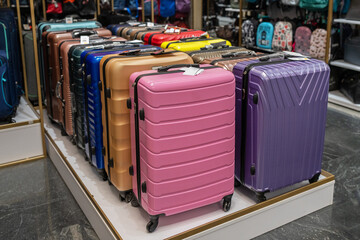 Large selection of colorful suitcases in store. Travel suitcases for sale at the mall.