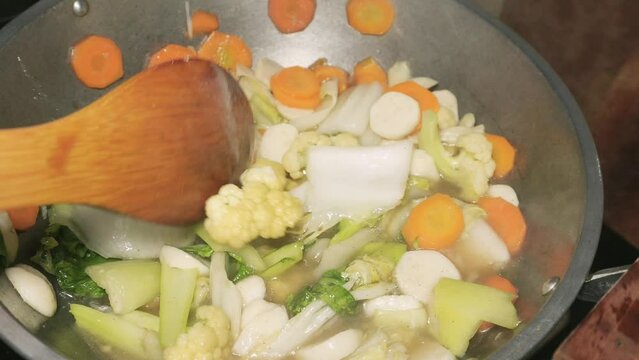 cooking Capcay vegetables. There are several types of vegetables in capcay such as Chinese cabbage, carrots, corn, straw mushrooms, ear mushrooms,cabbage, snow peas, broccoli, spring onions and onions