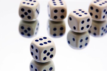 fünf Würfel auf weissem verspiegeltem Untergrund die alle die Zahl 6 zeigen