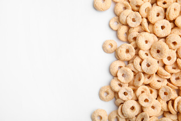 Tasty cereal rings on white background, flat lay. Space for text