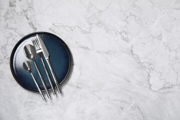 Stylish setting with elegant cutlery on white marble table, top view. Space for text