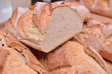 Close up view of homemade bread on a wood table photographed in ambiental light.Food photography details. Selective focus.