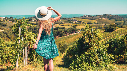 Obraz premium Young female with summer hat and blue dress in Tuscany landscape in Italy