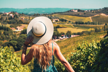 Fototapeta premium Young female with summer hat and blue dress in Tuscany landscape in Italy