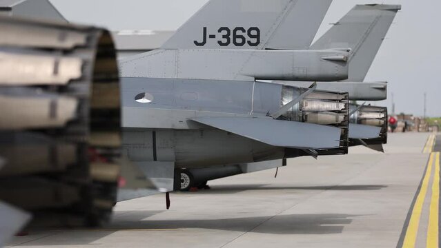 Fighter jet exhaust nozzle detail on a lot of fighter airplanes in parking position. 